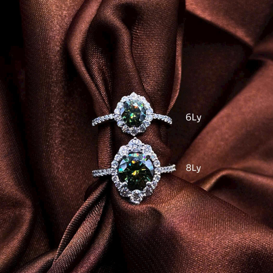 Pair of diamond earrings on brown fabric with '6Ly' and '8Ly' labels.