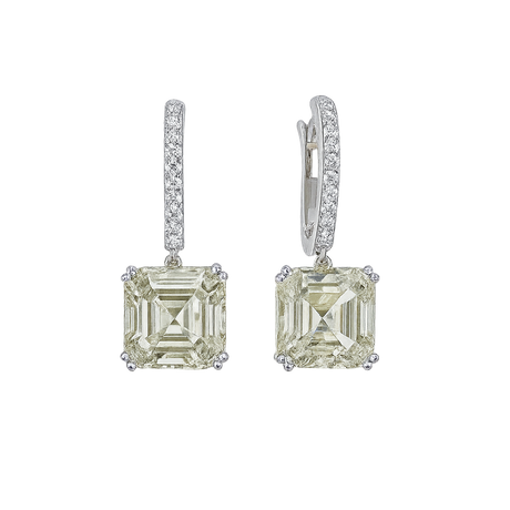 Pair of diamond earrings with green gemstones on a white background