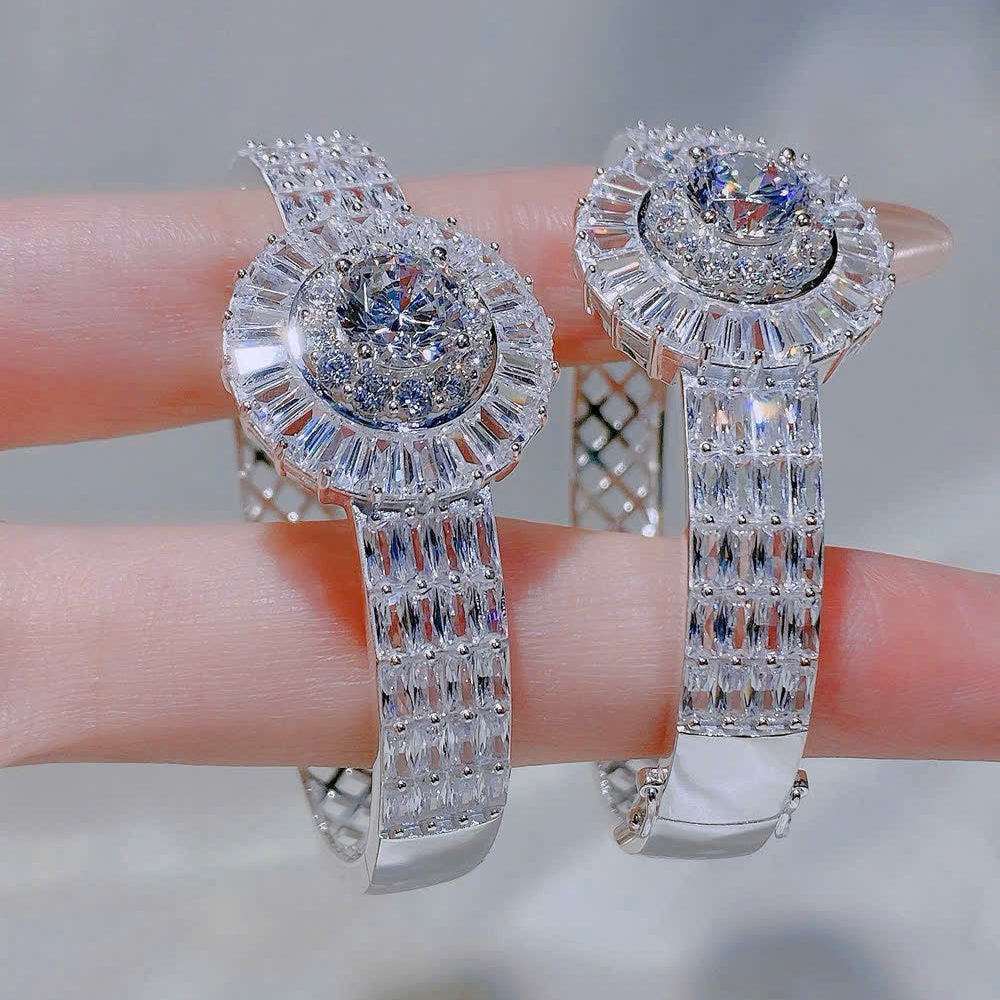 Pair of silver bracelet with clear gemstones on a blurred background