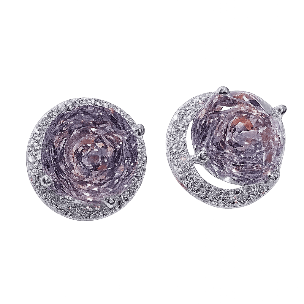 Pair of silver earrings with purple gemstones on a green background