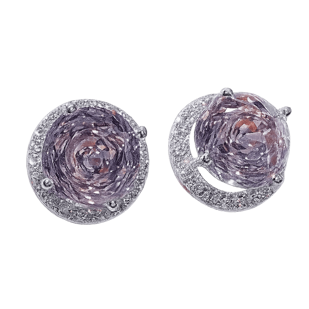 Pair of silver earrings with purple gemstones on a green background