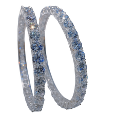 Pair of silver hoop earrings with blue gemstones on a white background