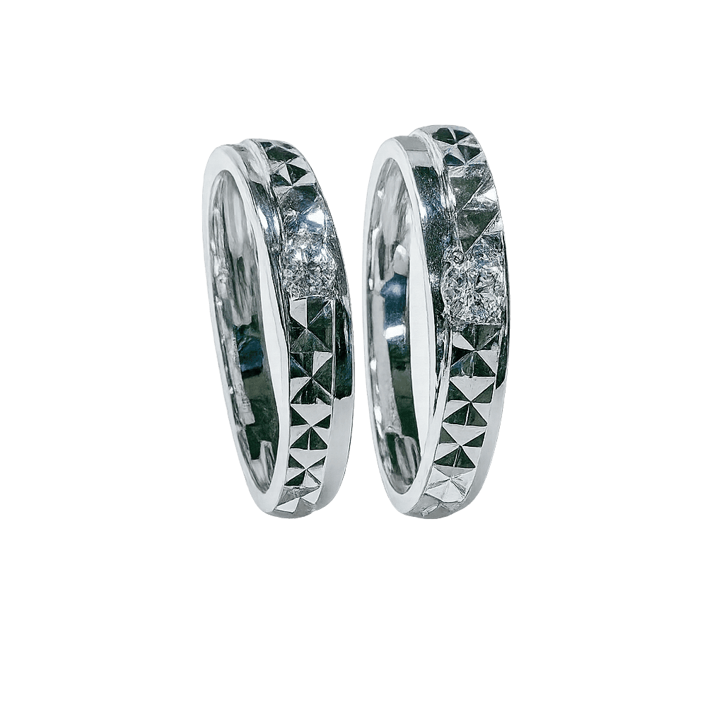 Pair of silver rings with geometric designs on a green background