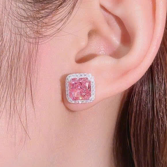 Pink diamond earring worn by a person