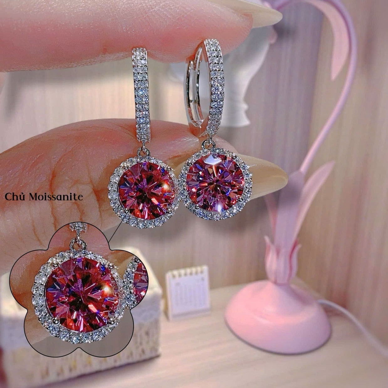 Pink gemstone earrings on a stand with a blurred background
