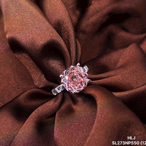 Pink rose-shaped jewelry on a brown fabric background