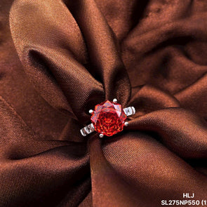 Red rose-shaped jewelry piece on brown fabric