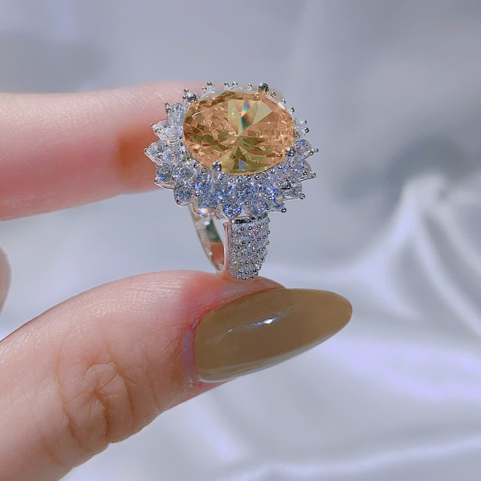 Ring with a large yellow gemstone and smaller diamonds on a blurred background