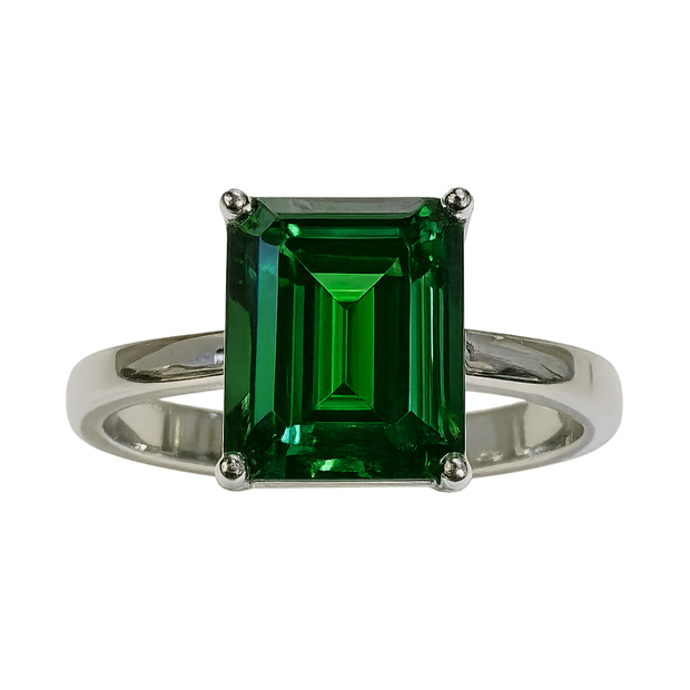 Ring with a green emerald-cut gemstone on a white background
