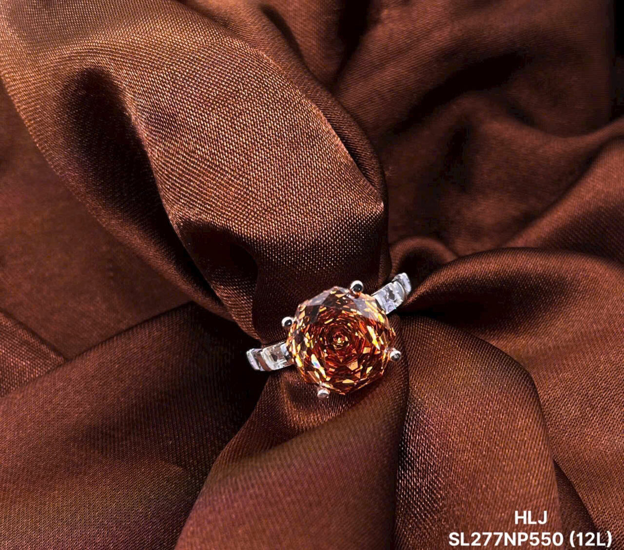Ring with a large brown gemstone on brown fabric