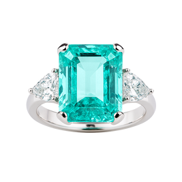 Ring with a large emerald-cut green gemstone and smaller clear stones on a white background