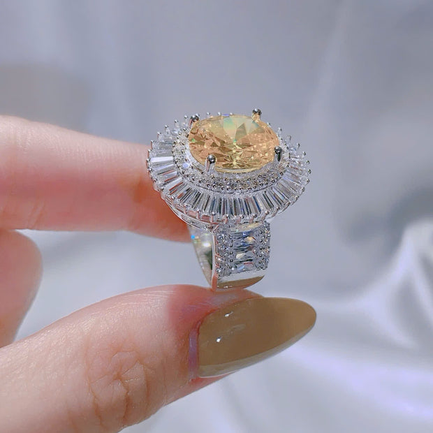Ring with a large gemstone held by a hand against a light background