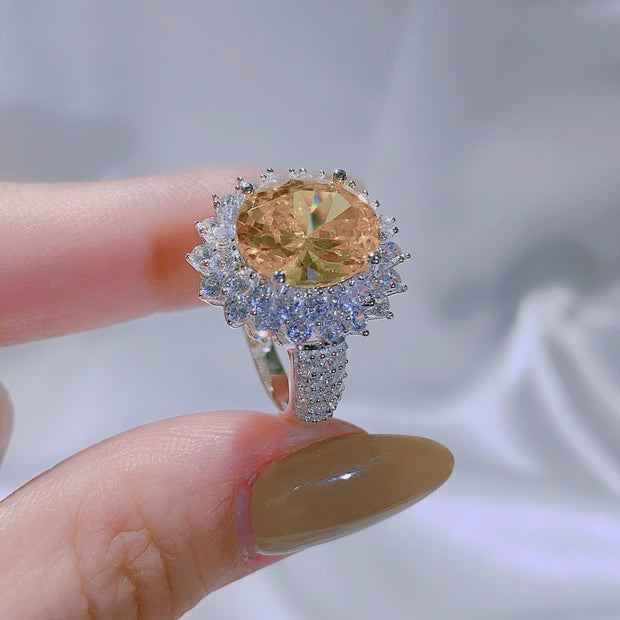 Ring with a large yellow gemstone and smaller diamonds on a blurred background