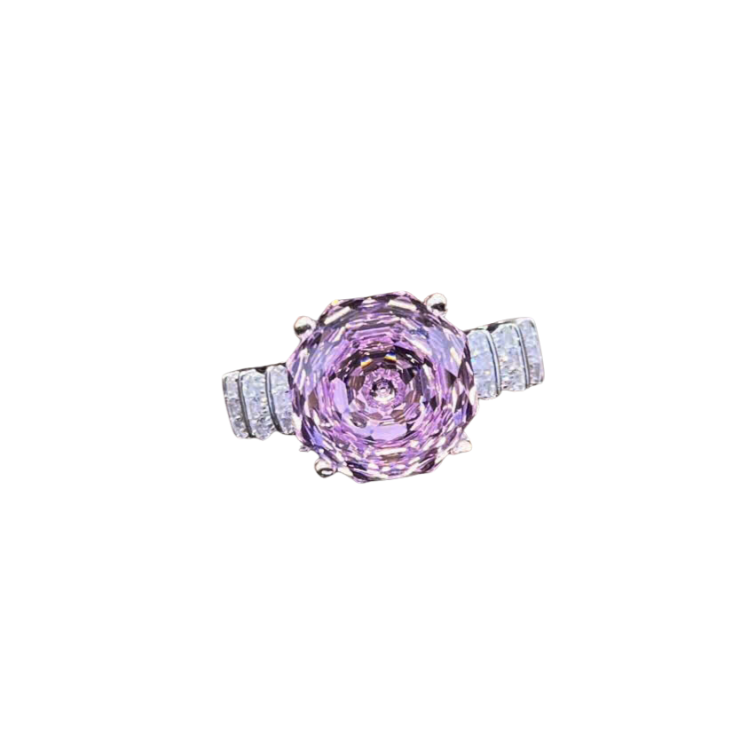 Ring with a pink gemstone and diamond accents on a white background