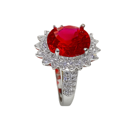 Ring with a red gemstone and diamond-studded band on a white background