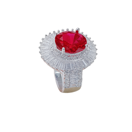 Ring with a red gemstone and diamond-studded band on a white background