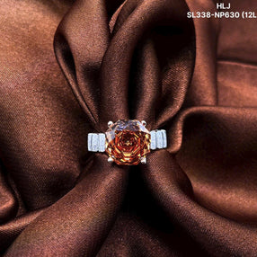 Ring with a rose-shaped gemstone on brown fabric, featuring brand 'HLJ'.