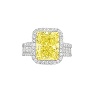 Ring with a yellow diamond and white gemstones on a white background