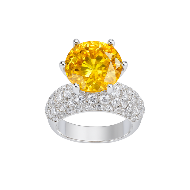 Ring with a yellow gemstone and diamond-studded band on a white background