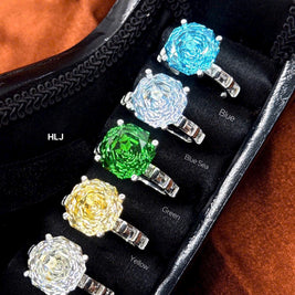 Set of colorful gemstone rings displayed on a black stand with color labels.