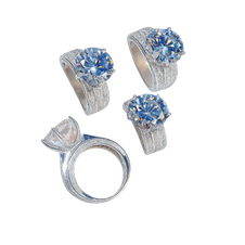 Set of silver rings with blue gemstones on a white background