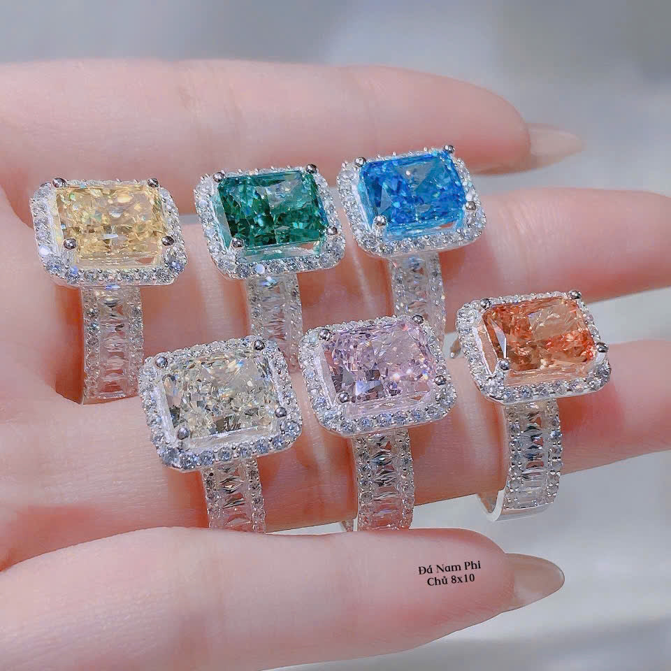 Set of six diamond rings with different colored gemstones on a hand.