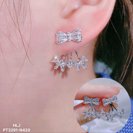 Silver bow-shaped earrings worn on an ear with a close-up inset.