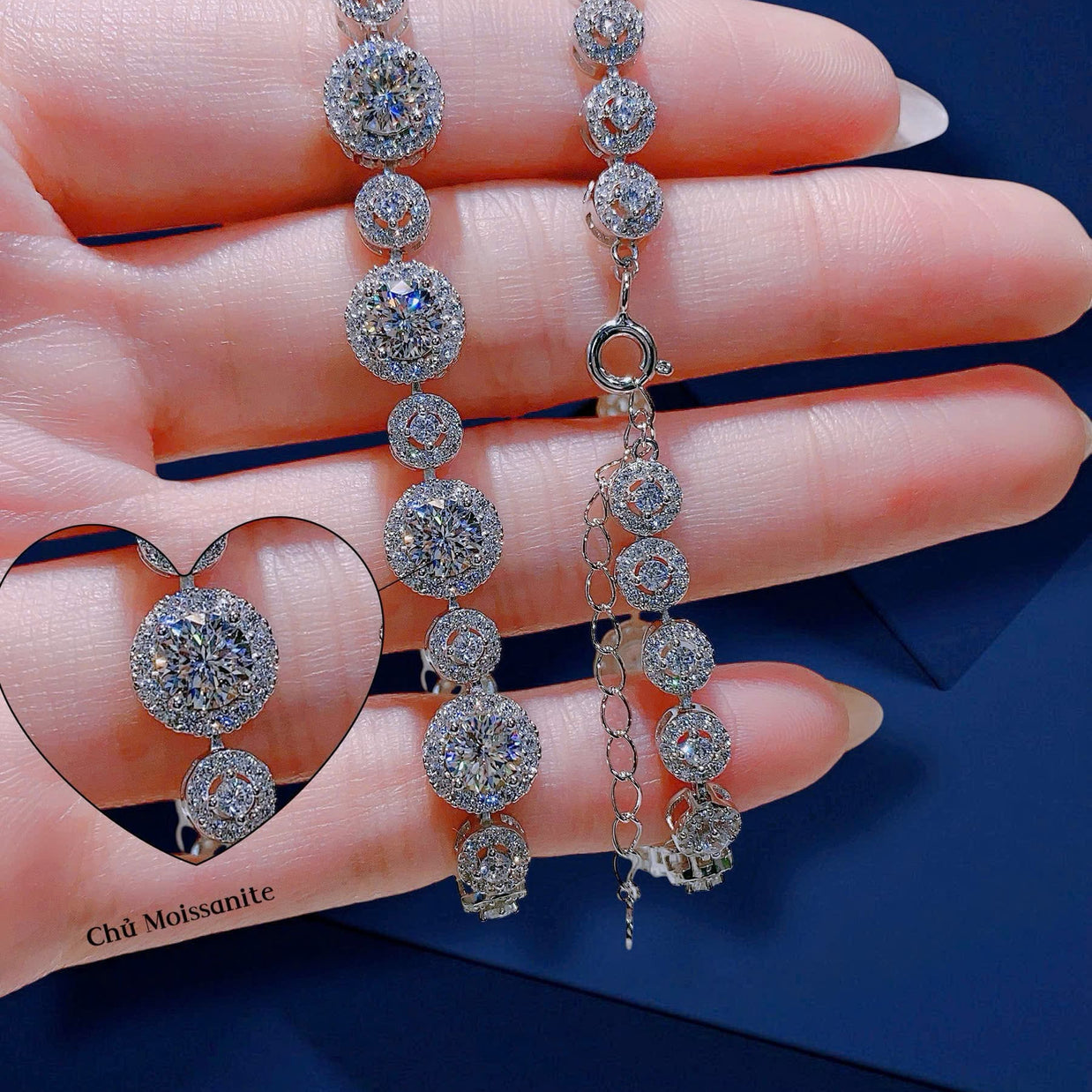 Silver bracelet and earrings on a hand with a blue background