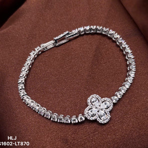 Silver bracelet with a floral clasp on a brown fabric background