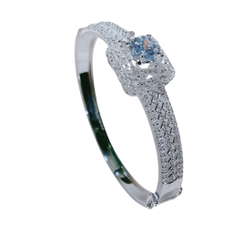 Silver bracelet with blue gemstones held by a hand against a blurred indoor background