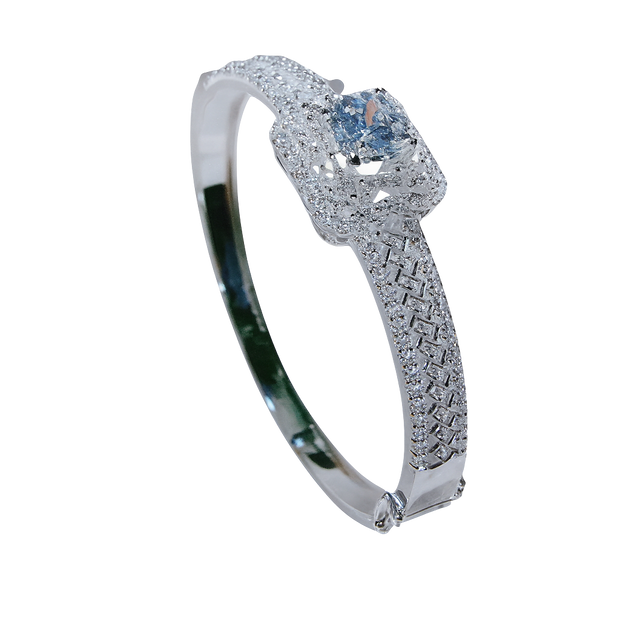 Silver bracelet with blue gemstones held by a hand against a blurred indoor background