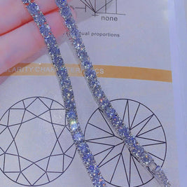 Silver bracelet with blue stones held over a chart with geometric designs.