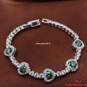 Silver bracelet with green and clear gemstones on a brown background