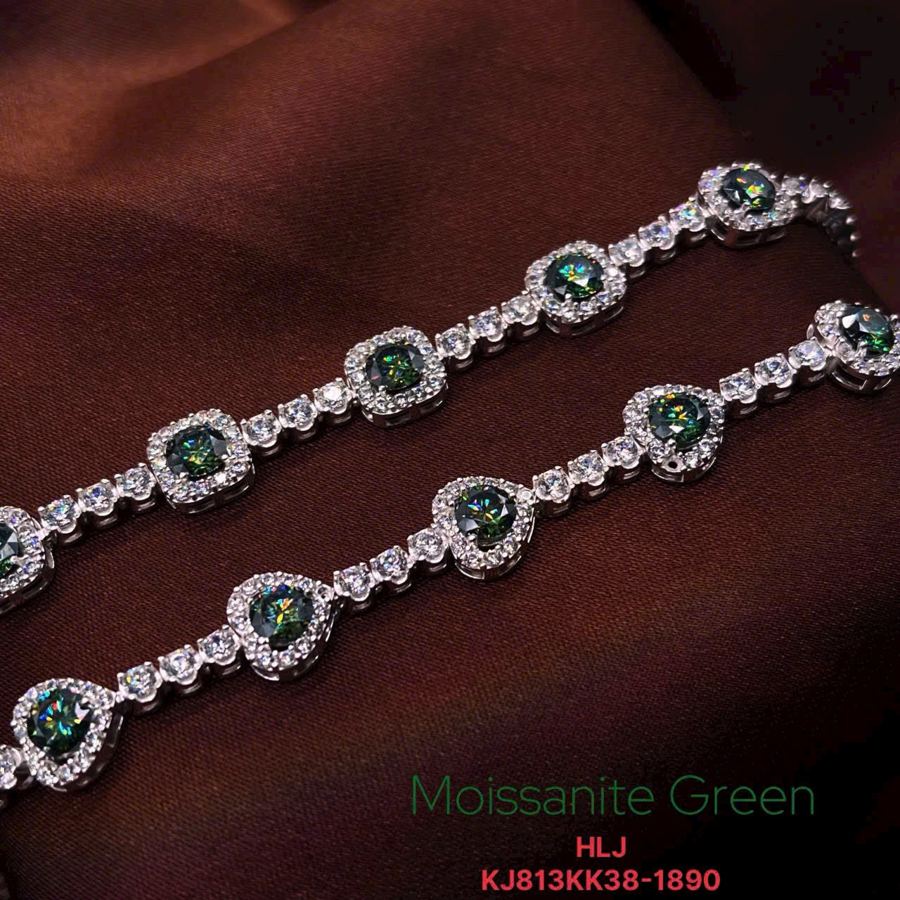Silver bracelet with green gemstones on a brown fabric background