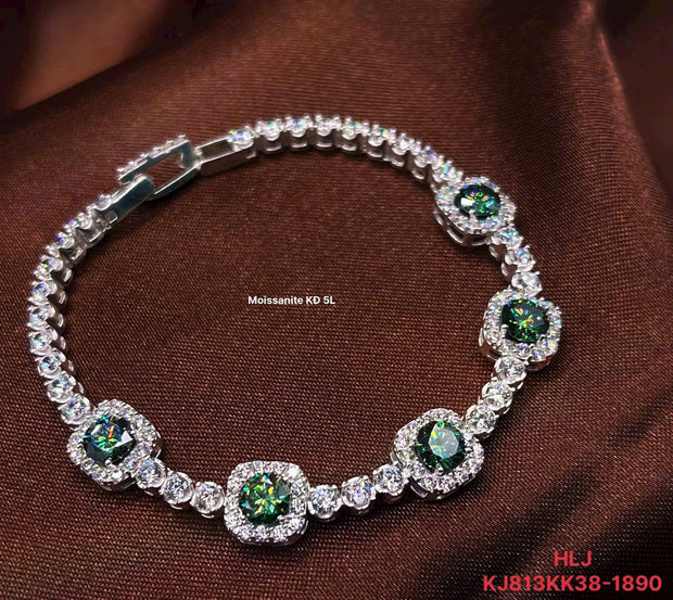 Silver bracelet with green gemstones on a brown fabric background