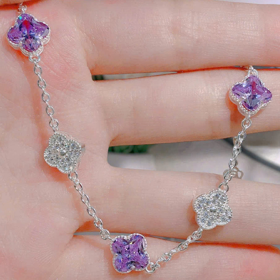 Silver bracelet with purple and clear gemstones on a hand