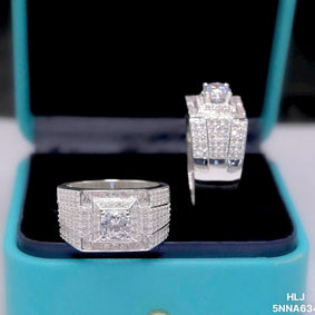 Silver diamond ring and earring set on a turquoise stand with a blurred background