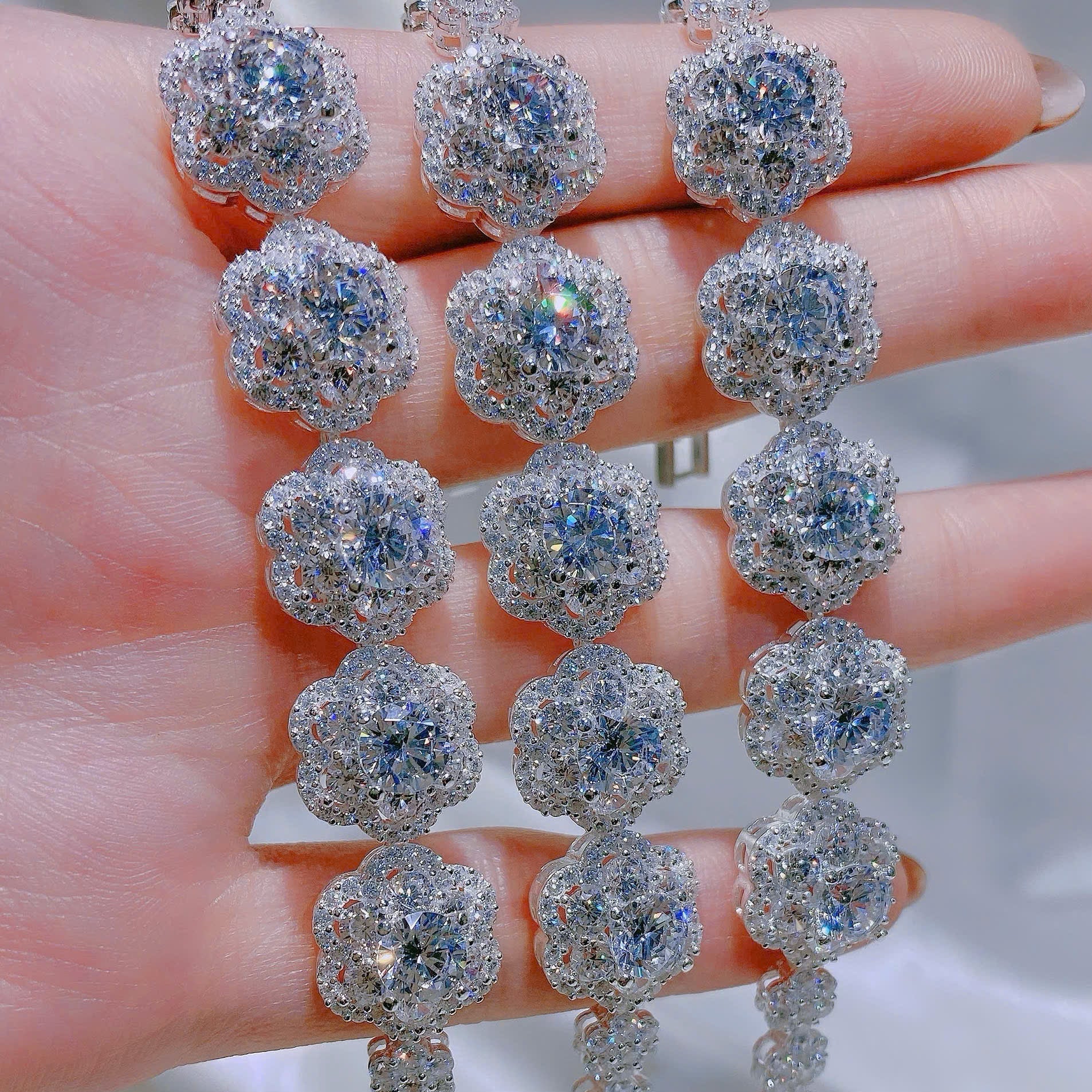 Silver earrings with large gemstones held in a hand against a neutral background