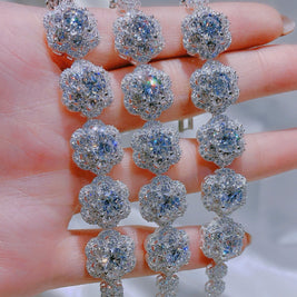 Silver earrings with large gemstones held in a hand against a neutral background