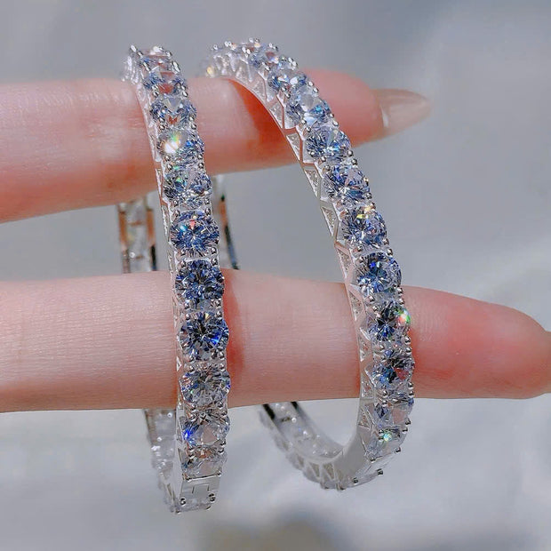 Silver hoop earrings with gemstones on a blurred background