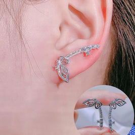 Silver leaf-shaped earring worn on an ear with a close-up inset showing the earring.