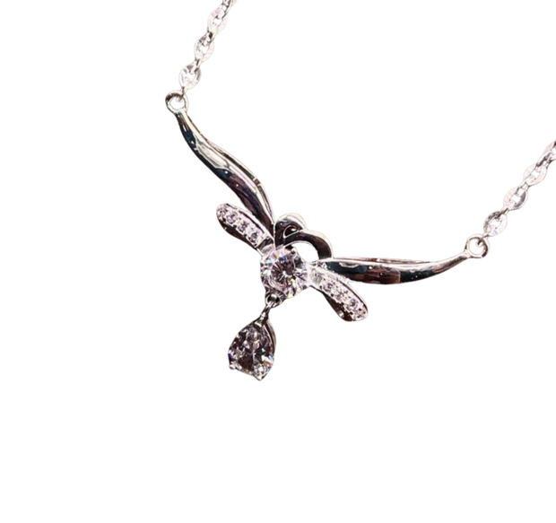 Silver necklace with a bow-shaped pendant on a white background