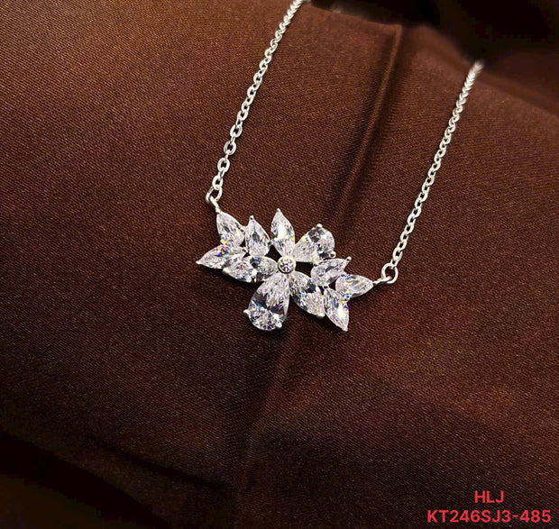 Silver necklace with a floral pendant on a brown fabric background