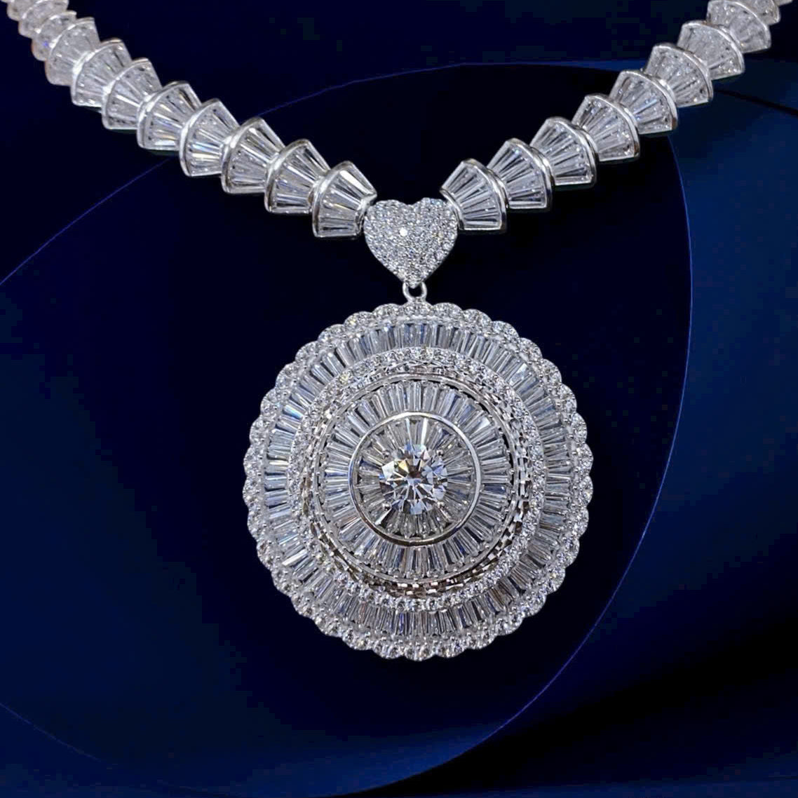 Silver necklace with a large, intricate pendant on a dark background