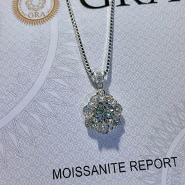 Silver necklace with a moissanite pendant on a GRA moissanite report card.