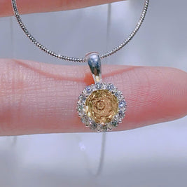 Silver necklace with a pendant held on a hand against a blurred background