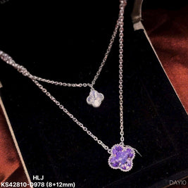 Silver necklace with a purple pendant on a dark background