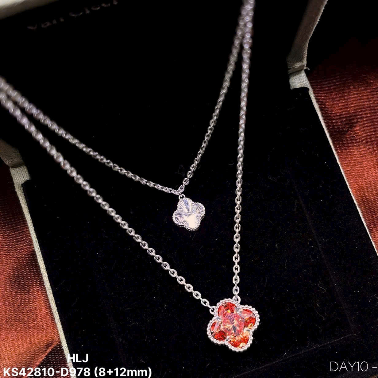 Silver necklace with a red flower pendant on a black background
