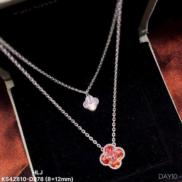Silver necklace with a red flower pendant on a black background