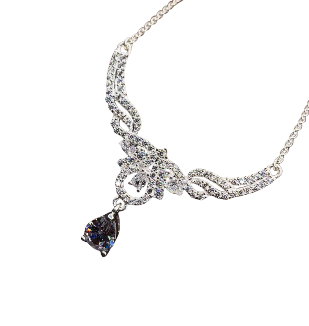 Silver necklace with a teardrop-shaped purple gemstone on a white background